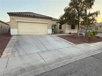 Charming single-story home featuring a two-car garage, desert landscaping, and a welcoming front porch at 6617 Johnny Love Ln, North Las Vegas, NV 89086