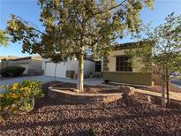 Charming single-story home with desert landscaping and a mature shade tree in the front yard at 6617 Johnny Love Ln, North Las Vegas, NV 89086