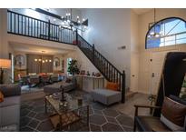 Bright, open living room with high ceilings, staircase, and contemporary furnishings for a welcoming ambiance at 9013 Cypress Point Way, Las Vegas, NV 89117