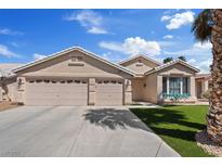 Charming single-story home featuring a three-car garage, manicured lawn, and desert landscaping under a bright blue sky at 9096 Nomo St, Las Vegas, NV 89123