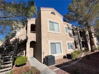 Two-story stucco condo with staircase and landscaping against a blue sky at 9470 Peace Way # 112, Las Vegas, NV 89147