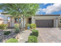 Charming single-story home featuring a well-manicured front yard and a brick driveway leading to a two-car garage at 10127 Knotty Skye Ave, Las Vegas, NV 89166