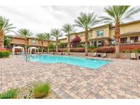 Community pool surrounded by palm trees, lounge chairs, and manicured landscaping at 10356 Addie De Mar Ln, Las Vegas, NV 89135