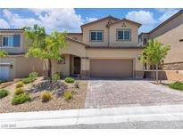 Inviting two-story home with a well-manicured front yard and a charming brick driveway at 10415 Sadie Blake Ave, Las Vegas, NV 89166