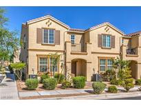 Inviting townhouse featuring stucco exterior, landscaped yard, and charming architectural details at 1201 Seaboard Ct, Henderson, NV 89002