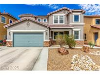 Charming two-story home with a two-car garage and desert landscaping with a beautiful, natural rock feature at 140 Rolling Cove Ave, Henderson, NV 89011