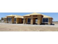Exterior view of a home under construction, showing framing and window installation progress at 1550 W Jornada St, Pahrump, NV 89048