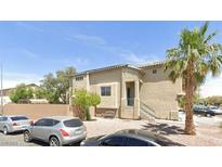 Beige two-story home with a tile roof, gravel landscaping, and a mature palm tree in the front yard at 3591 Gloucester Gate St, Las Vegas, NV 89122