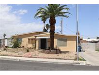 Charming single-story home with a palm tree in front and a brick-lined walkway to the front door at 513 Berry Cir, Las Vegas, NV 89107