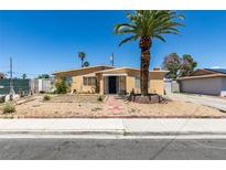 Charming single-story home featuring desert landscaping, a front yard palm tree, and a covered front porch at 513 Berry Cir, Las Vegas, NV 89107