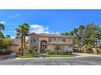 Elegant two-story home featuring a tiled roof, desert landscaping, and a secure gated entrance at 5445 Pendini Point Ct, Las Vegas, NV 89141