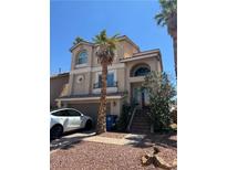 Charming two-story home features a stucco exterior, arched windows, and a well-manicured front yard at 6877 Philharmonic Ave, Las Vegas, NV 89139