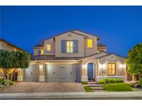 Inviting two-story home featuring a three-car garage, manicured lawn, and charming architectural details at 8126 Majestic Bighorn St, Las Vegas, NV 89166