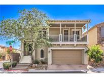 Charming two-story home boasts a covered balcony, tan siding, and a well-manicured front yard at 9822 Opal Bridge Ct, Las Vegas, NV 89178