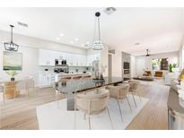 Bright open-concept dining room featuring a black marble table, seating for six, and modern light fixtures at 10017 Snow Crest Pl, Las Vegas, NV 89134