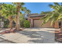 Charming single-story home featuring a well-kept lawn, desert landscaping, and an attached two-car garage at 10310 Songsparrow Ct, Las Vegas, NV 89135