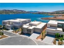 Stunning aerial view of modern homes on a waterfront property with beautiful lake and mountain views at 1596 Pleasant Bay Ct, Henderson, NV 89011