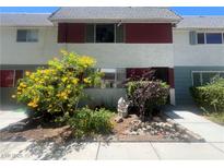 Charming townhome featuring colorful landscaping and a well-maintained front yard at 225 Greenbriar Townhouse Way, Las Vegas, NV 89121