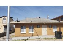 Single-story home featuring a brick facade, windows, and a security door, presenting a simple design at 2417 St George St, North Las Vegas, NV 89030