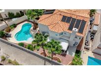 Stunning aerial view of a home with a private backyard pool, solar panels, patio, and mature landscaping at 4 Tarryall Ter, Henderson, NV 89074