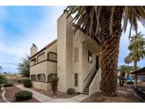 Charming multi-level building featuring stucco walls, a tile roof, and a mature palm tree in a desert landscape at 5040 Spencer St # D, Las Vegas, NV 89119