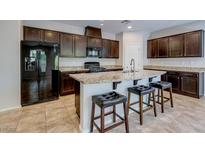 Beautiful kitchen featuring granite countertops, dark cabinets, tile flooring, and stainless steel appliances at 5412 Dalle Valley St, North Las Vegas, NV 89031