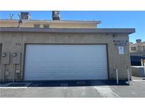 Exterior shot of attached garage at 6420 Little Pine Way, featuring a white door and neutral facade at 6420 Little Pine Way, Las Vegas, NV 89108