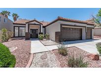 Charming single-story home featuring a well-manicured front yard with desert landscaping and a two-car garage at 8847 W Katie Ave, Las Vegas, NV 89147