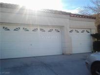 Attached two-car garage featuring white doors with decorative windows, providing convenient parking and storage at 8847 W Katie Ave, Las Vegas, NV 89147