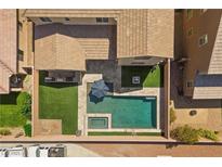 Aerial view of backyard featuring a pool, spa, patio, artificial turf, and fire pit at 8953 Hitch Creek St, Las Vegas, NV 89131