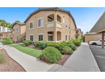 A tan condo building shows a front yard with green shrubs and a walkway at 8985 S Durango Dr # 1110, Las Vegas, NV 89113