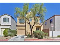 Two-story home with desert landscaping, a garage, and a tree in the front yard at 10162 Sunshine Village Pl, Las Vegas, NV 89183