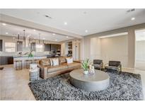 Spacious living room with a leather couch, large round coffee table, and open floor plan to the modern kitchen at 11280 Granite Ridge Dr # 1035, Las Vegas, NV 89135
