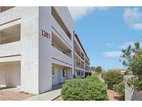 Apartment building featuring multiple balconies and well-maintained landscaping at 1381 E University Ave # 310, Las Vegas, NV 89119