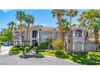 Stunning gray two-story home boasting manicured lawns and palm trees at 1931 Pago Ct, Las Vegas, NV 89117