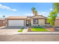 Charming single-story home featuring a well-maintained front yard, a two-car garage, and mature trees at 251 Las Palmaritas Dr, Las Vegas, NV 89110
