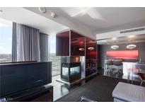 Modern living room features a fireplace and city views, plus an integrated bar and seating area at 4381 W Flamingo Rd # 2122, Las Vegas, NV 89103