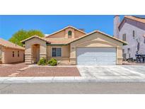 Inviting single-story home with a charming tiled roof, two-car garage, and desert landscaping in a vibrant community at 4619 Reliant St, North Las Vegas, NV 89031