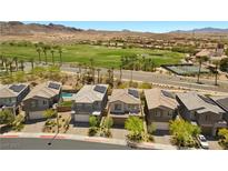 Gorgeous aerial view of homes in a community with a golf course, palm trees and desert mountains in the background at 55 Strada Fontana, Henderson, NV 89011