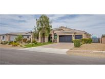 Beautiful single-story home with a three-car garage, manicured landscaping, and brick-paved driveway at 6060 N Conquistador St, Las Vegas, NV 89149