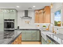 Modern kitchen boasts two-tone cabinets, stainless appliances, apron sink, and elegant countertops at 6920 Bradley Rd, Las Vegas, NV 89131