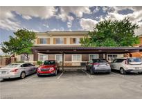 Exterior view of the complex with covered parking spaces and multiple cars parked underneath at 9303 Gilcrease Ave # 2198, Las Vegas, NV 89149