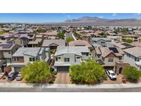 Suburban homes with mountain backdrop, featuring mature landscaping and architectural variety at 9710 Hiking Ave, Las Vegas, NV 89166