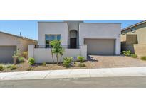 Modern two-story home featuring desert landscaping, a brick driveway, and a two-car garage at 11707 Hatchling Ave, Las Vegas, NV 89138