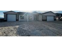 Charming single-story home with a symmetrical facade, featuring a gravel driveway and a two-car garage on each side at 1760 Omaha Ave, Pahrump, NV 89048