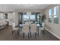 Open dining area featuring a modern light fixture and sliding glass doors to the outdoor living space at 2246 Bird Of Prey St, Las Vegas, NV 89138