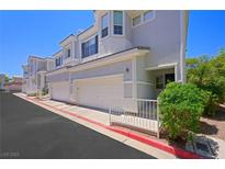 Inviting townhome featuring a two-car garage and lovely architectural details on a bright, sunny day at 245 Homesteader Ct, Henderson, NV 89052