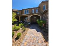 Charming townhouse with a stone-accented facade, covered porch, and a well-manicured front yard at 2497 Rofrano Pl, Henderson, NV 89044