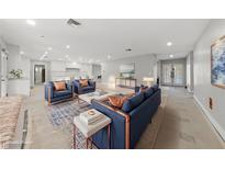 Bright, staged living room boasts blue furniture, recessed lighting, and open floor plan at 3075 Santa Margarita St, Las Vegas, NV 89146