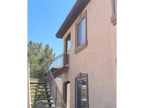 Tan condo exterior with a brown metal staircase and stucco facade under a bright blue sky at 3360 Cactus Shadow St # 203, Las Vegas, NV 89129